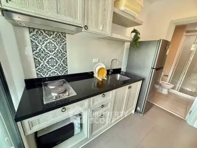 Modern kitchen with sleek black countertop and stylish backsplash in a cozy apartment.