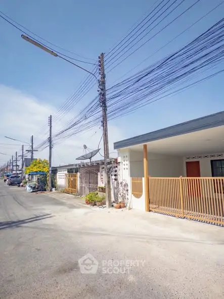 Charming suburban street view with modern single-story homes and clear blue skies.