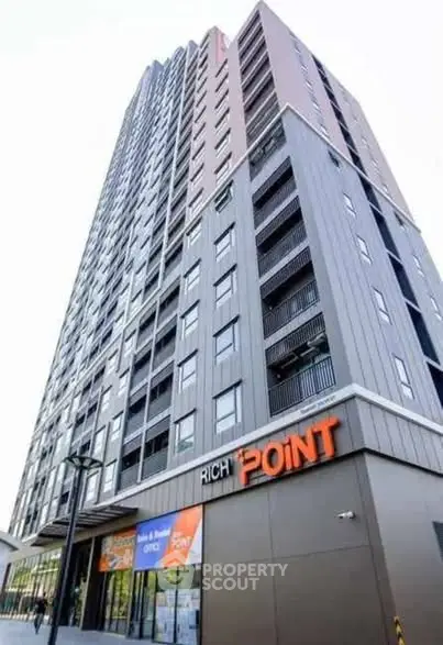 Modern high-rise building with sleek architecture and prominent signage, ideal for urban living.