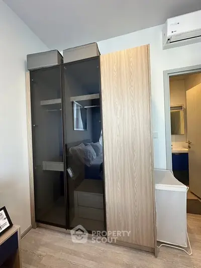 Modern bedroom with sleek wardrobe and air conditioning unit