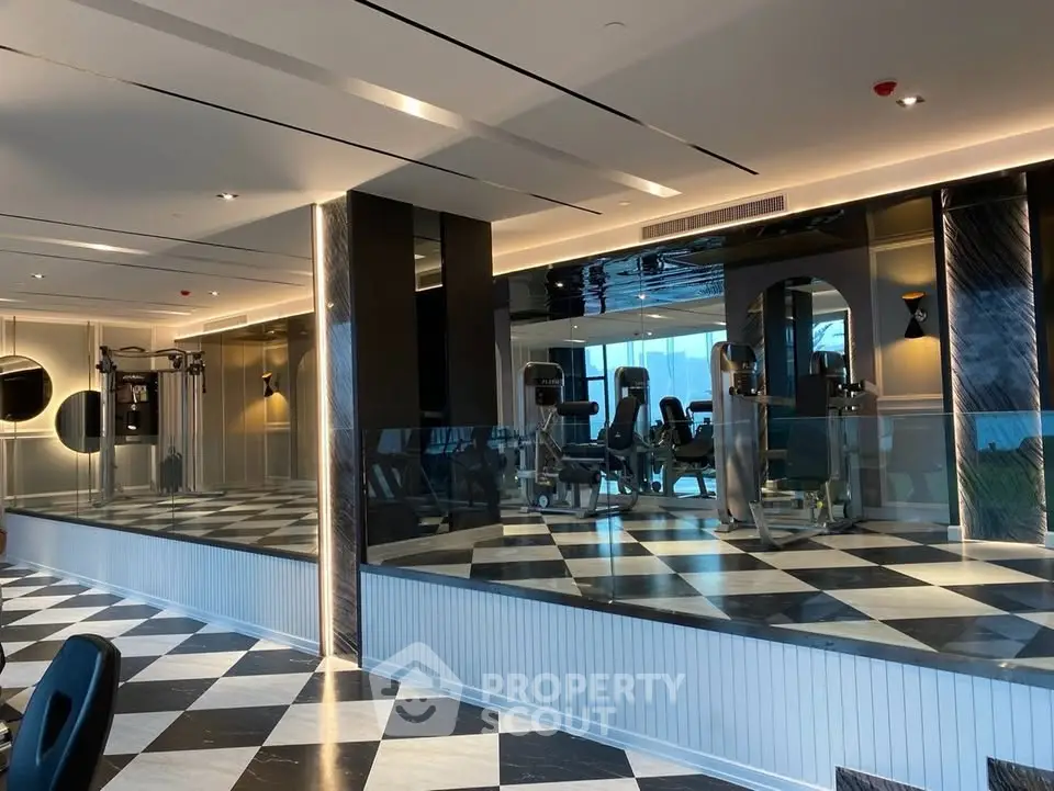 Luxurious modern gym with mirrored walls and stylish checkered flooring in upscale building.
