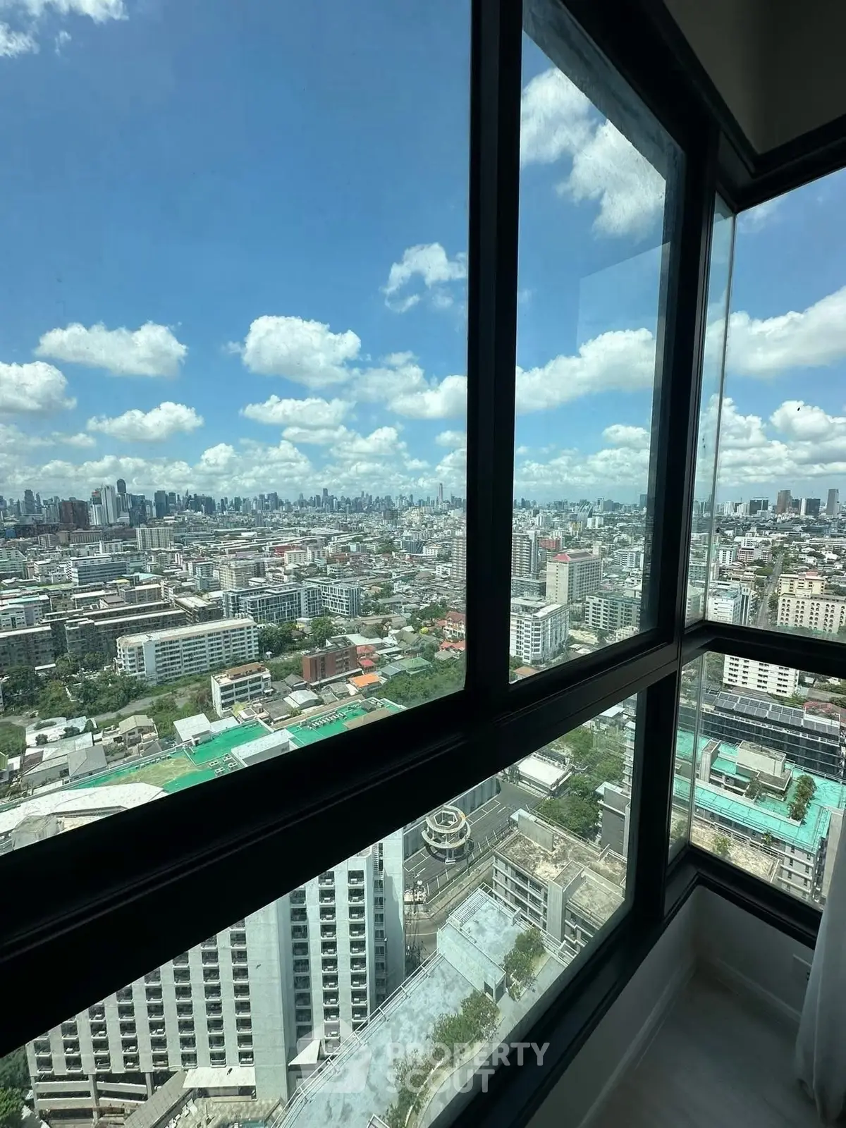 Stunning cityscape view from high-rise apartment window on a clear day.