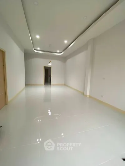 Spacious modern living room with sleek lighting and glossy tile flooring