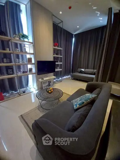 Modern living room with stylish furniture and large windows in a high-rise apartment.