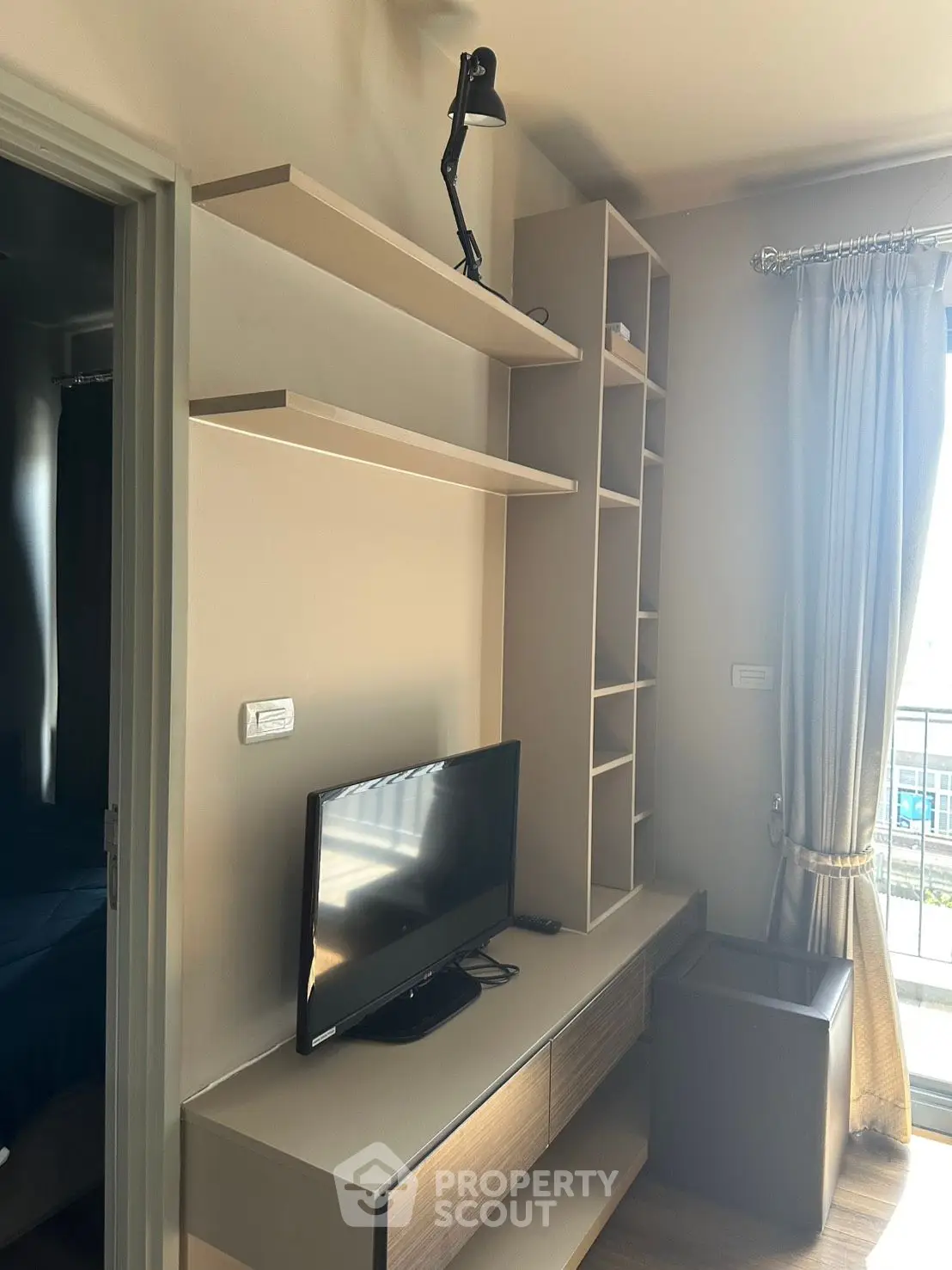 Modern living room with sleek TV stand and open shelving, perfect for stylish urban living.