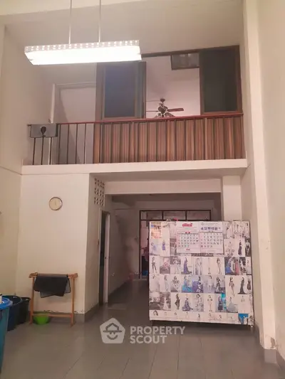 Spacious interior with high ceiling and mezzanine, ideal for creative living or office space.
