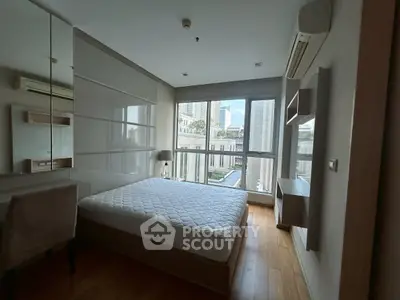 Modern bedroom with large window and city view, featuring sleek design and natural light.