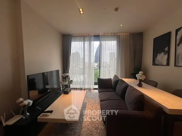 Modern living room with large windows and city view, featuring sleek furniture and elegant decor.
