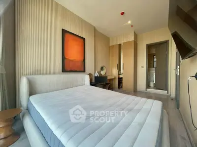 Modern bedroom with stylish decor and ensuite bathroom in luxury apartment.