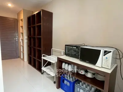 Modern kitchen with microwave and oven, sleek shelving, and organized dishware in a contemporary apartment.
