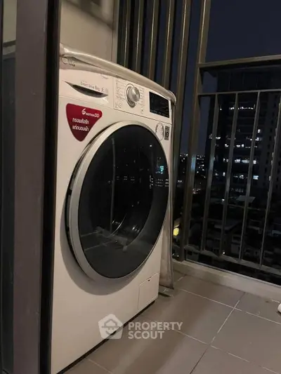 Modern washing machine on balcony with city night view, perfect for urban living convenience.