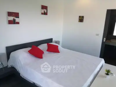 Modern bedroom with minimalist decor and vibrant red accents