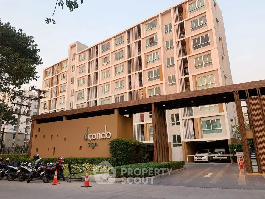 Modern condominium building with stylish entrance and parking area