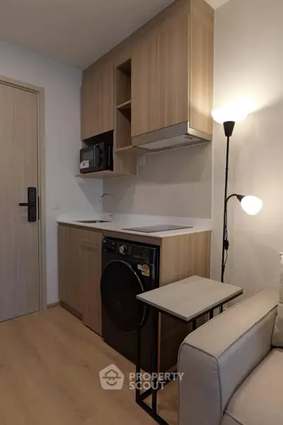 Modern compact kitchen with integrated appliances and cozy seating area