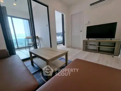 Modern living room with balcony view and stylish furniture in a high-rise apartment.