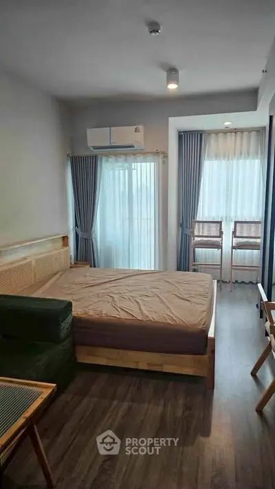 Modern bedroom with large windows and stylish decor in a contemporary apartment.