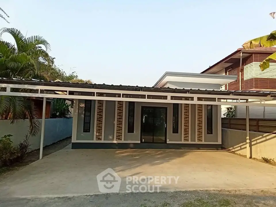 Modern single-story house with spacious driveway and contemporary design.