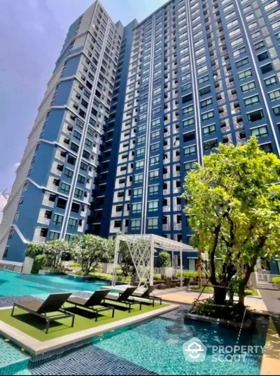 Luxurious high-rise condominium with poolside relaxation area and lush greenery.