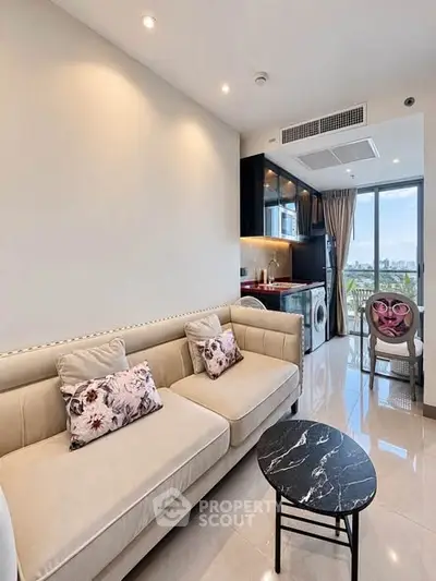 Modern living room with elegant sofa and open kitchen, featuring a scenic view from the balcony.