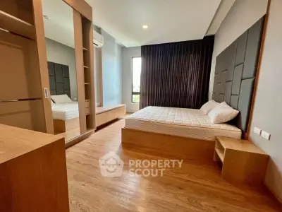 Modern bedroom with wooden flooring and stylish headboard in a cozy apartment.