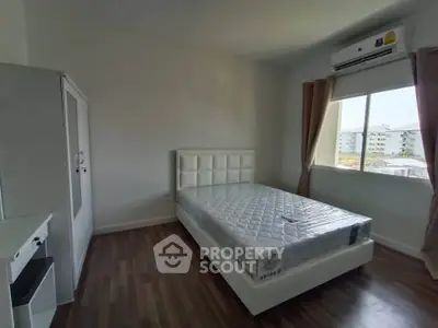 Modern bedroom with large window and stylish furniture in a bright apartment.