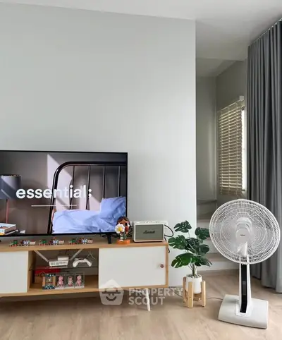 Modern living room with stylish TV stand, fan, and decor accents