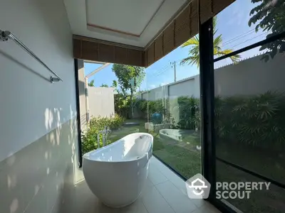 Luxurious bathroom with freestanding bathtub and garden view