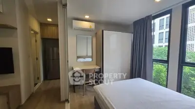 Modern bedroom with large windows and sleek furniture in a contemporary apartment.