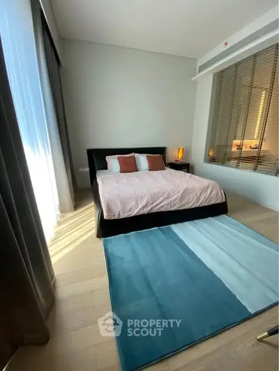 Modern bedroom with stylish decor and large window for natural light.