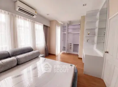 Spacious bedroom with large windows and built-in storage in modern apartment