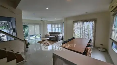 Spacious open-plan living and dining area with modern furnishings and large windows.