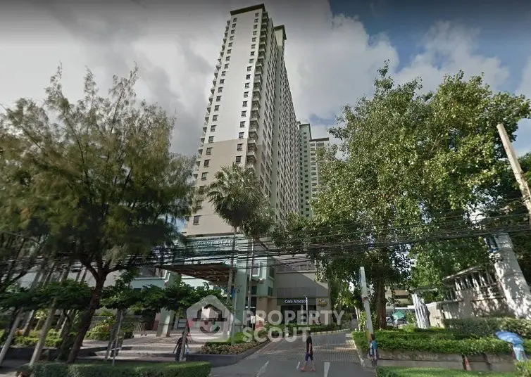 Modern high-rise residential building with lush greenery and clear sky