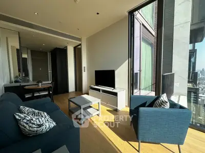 Modern living room with large windows and stylish furniture in a high-rise apartment.