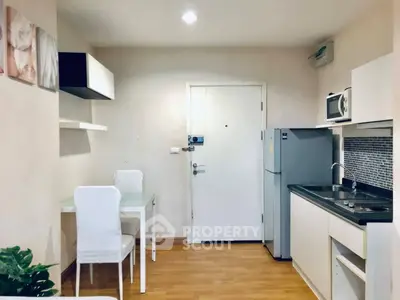 Modern kitchen with sleek appliances and dining area in cozy apartment