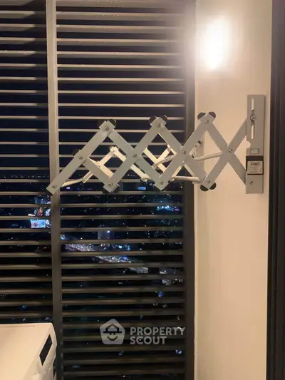 Modern balcony with sleek metal drying rack and city night view