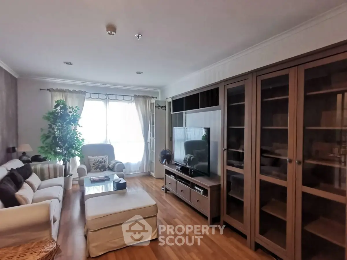 Spacious living room with elegant wooden flooring and modern furniture, perfect for relaxation and entertainment.