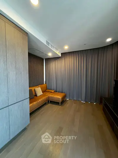 Modern living room with sleek wooden flooring and stylish leather sofa