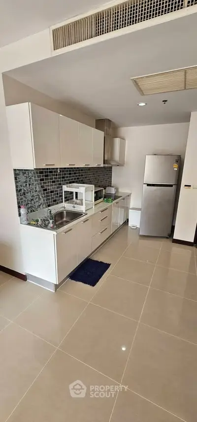 Modern kitchen with sleek cabinetry and stainless steel appliances in a stylish apartment.
