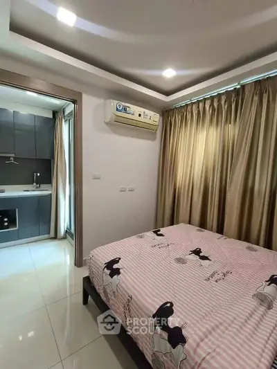 Cozy bedroom with modern air conditioning and adjacent kitchen view.
