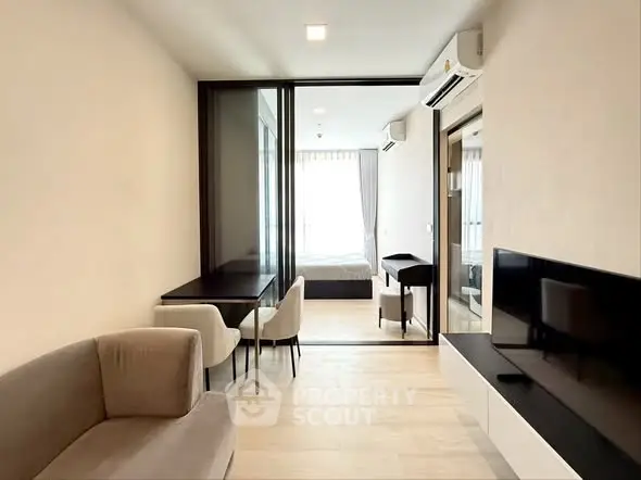 Modern apartment interior with open living and dining area, featuring sleek furniture and natural light.