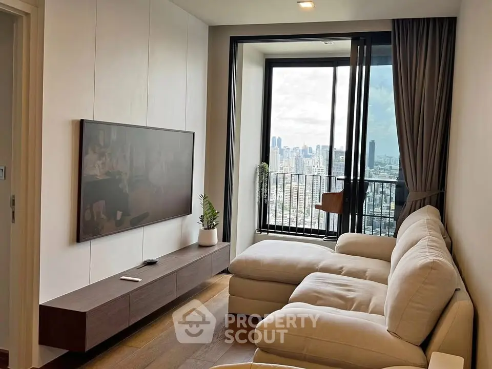 Modern living room with city view, featuring sleek furniture and large window for natural light.