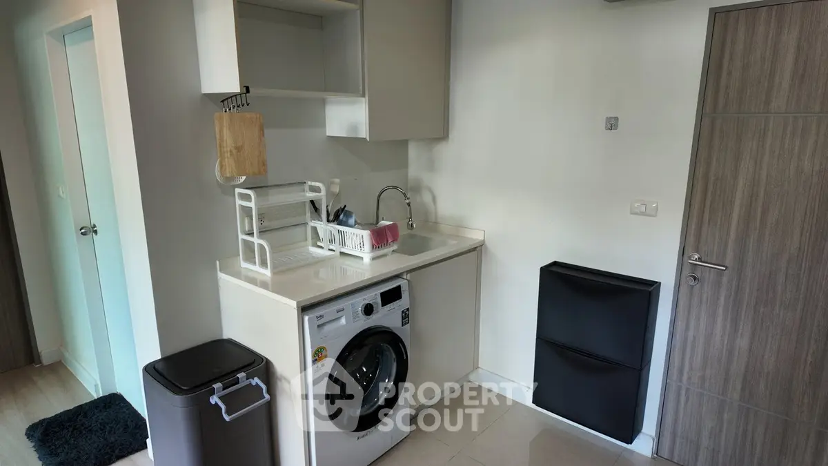 Modern laundry area with washing machine and storage in a sleek apartment