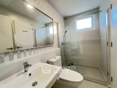 Modern bathroom with glass shower and stylish tile design.