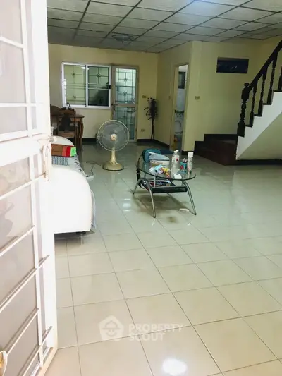 Spacious living room with tiled floor and modern furniture, ideal for family gatherings.