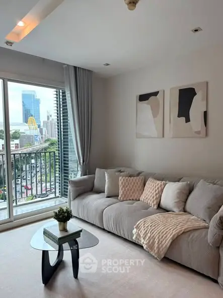 Modern living room with cozy sofa and city view from balcony