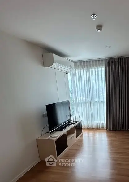 Modern living room with TV and large window offering natural light