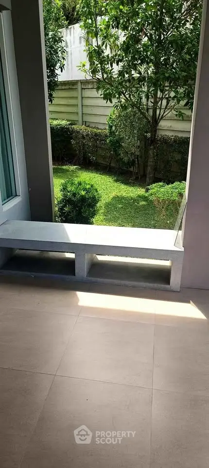 Charming garden view from a modern patio with lush greenery and sleek design.