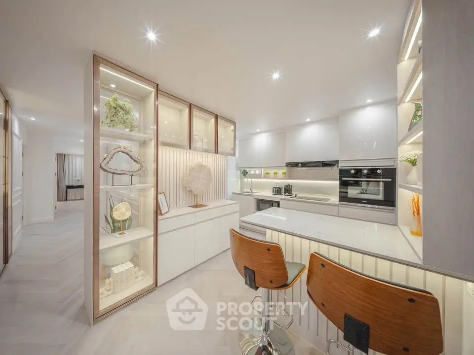 Luxurious modern kitchen with sleek cabinetry and stylish bar stools, perfect for entertaining.