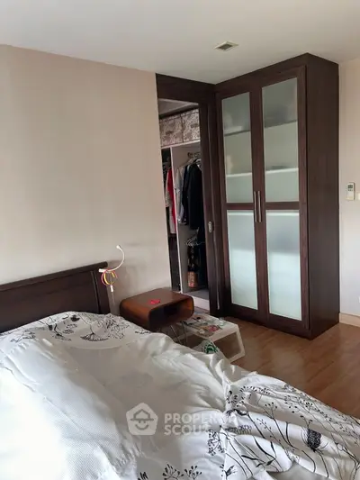 Cozy bedroom with walk-in closet and stylish wooden furniture