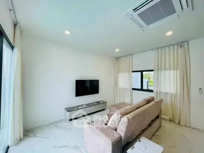 Modern living room with sleek design, featuring a wall-mounted TV and plush sofa under recessed lighting.
